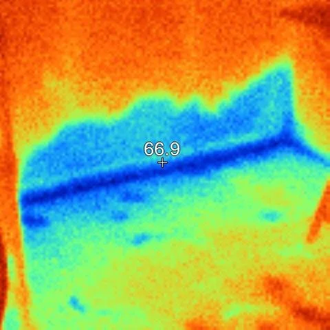 Thermal image showing a cooler area along a wall and floor